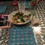 photo of a bingo card and salad on a table